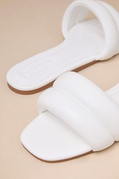 From running errands to poolside hangs, there's no better pick than the D'Amelio Footwear Kovella Bright White Faux Leather Flat Slide Sandals! Smooth faux leather shapes these trendy sandals with a square toe footbed and a wide vamp strap with a puffy, quilted-like effect. The easy slide-on design makes for effortless styling on the go! 0. 25" rubber heel. Cushioned insole. Rubber sole has nonskid markings. Man Made Materials. Imported. Lulus | Kovella Bright White Faux Leather Flat Slide Sanda Beach Slides With Padded Open Heel, Luxury Synthetic Sandals For Vacation, Beach Mules With Padded Heel And Single Toe Strap, Chic Slides With Cushioned Footbed And Flat Heel, Chic Slides With Cushioned Footbed, Luxury Synthetic Sandals For The Beach, Chic Leather Slides With Padded Heel, Luxury Synthetic Beach Sandals, Chic Leather Mules For Vacation