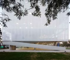 the building is covered in glass and has stairs leading up to it's sides