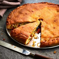 a pie that has been cut in half on a plate with a knife next to it