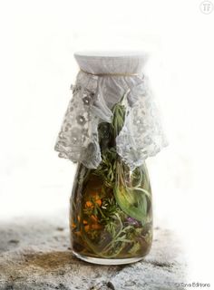 a vase filled with flowers and lace on top of a table