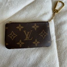 Authentic Louis Vuitton Key Pouch Excellent Condition Made In France Comes W Dust Bag And Box Date Code Is Ct2127 (Unsure About Second To Last Digit As It Is Very Hard To Read) The Key Pouch In Iconic Monogram Canvas Is A Playful Yet Practical Accessory That Can Carry Coins, Cards, Folded Bills And Other Small Items, In Addition To Keys. Secured With An Lv-Engraved Zip, It Can Be Hooked Onto The D-Ring Inside Most Louis Vuitton Bags, Or Used As A Bag Or Belt Charm. Product Details 4.7 X 2.8 X 0.4 Inches (Length X Height X Width) Monogram Coated Canvas Grained Cowhide-Leather Lining Gold-Color Hardware Zip Closure Key Ring Chain With Hook Louis Vuitton Key Pouch, Key Pouch, Ring Chain, Louis Vuitton Bags, Chain Ring, D Ring, Small Items, Monogram Canvas, Authentic Louis Vuitton