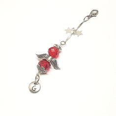 a red beaded key chain with silver angel charms on it's end and stars