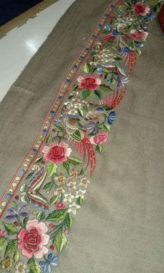 an embroidered table runner with flowers on it