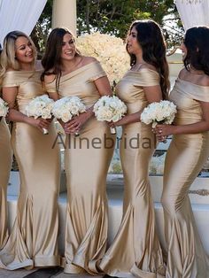 the bridesmaids are all wearing gold gowns and holding bouquets in their hands