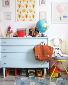 a child's room with a blue dresser and toy animals on the top shelf