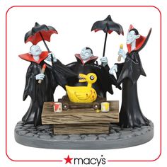 the three witches are holding their umbrellas over an object that is on top of a table