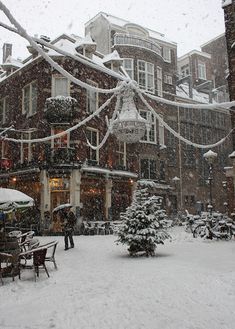 people are walking through the snow in front of buildings