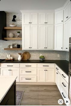 a kitchen with white cabinets and black counter tops