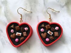 two red heart shaped earrings with chocolates and marshmallows in the middle