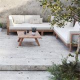 an outdoor living area with couches, tables and potted plants on concrete steps