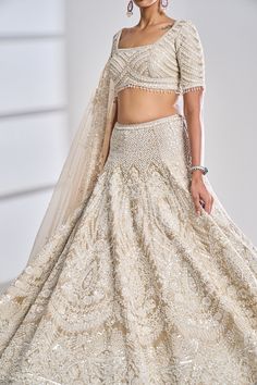 This nude raw silk lehenga set features intrictaet pearl, sequin and diamonte embroidery. It is paired with a fully embroidered blouse with tassels on the sleeves and a matching four sided organza dupatta.From Seema Gujral’s Night at the Opera collectionDELIVERY TIMEPlease wait 8-12 weeks for your outfit to arrive.FABRIC DETAILSRaw SilkProfessional cleaning only. Pearl Lehenga, Blouse Organza, Blouse With Tassels, Lehenga And Blouse, Raw Silk Lehenga, Vacuum Storage, Red Lehenga, Parsons School Of Design, Embroidered Dupatta