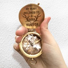 a person holding a gold pocket watch with the words my heart belongs to a deer hunter on it