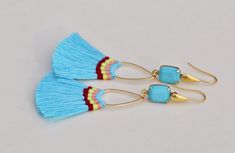 "Gorgeous new earrings made using hand made cotton tassels and vintage Swarovski crystal. The earrings are made with octagon shaped crystals that are opaque turquoise blue, set into gold plated settings. They hang from matte gold french ear wires with teardrop detail. Crystals connect to hand made cotton tassels, with colorful hand wrapped thread detail. Total earring length is 3\". For reference, tassels alone are 2\" long." Blue Tassel Earrings, Shaped Crystals, Blue Tassel, Earring Gold, Vintage Turquoise, Trendy Gift, Gold Earrings Dangle, Earrings Vintage, Matte Gold