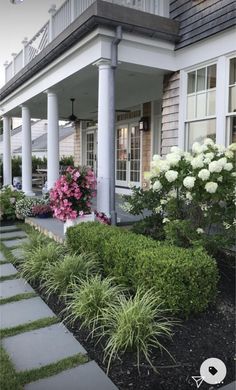 an image of a front yard with flowers and plants on the side of the house