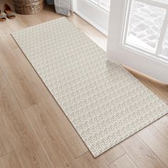 a white rug on the floor in front of a window