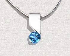 "Swiss Blue Topaz Necklace - Silver Argentium - 3460 - Argentium Chain Included A contemporary, yet timeless design by award winning designer, David Worcester. ( IMPORTANT - PLEASE READ 1. AND 2 BELOW ) 1.) INCLUDED IN THE PRICE IS AN ARGENTIUM SILVER CHAIN APPROPRIATE FOR THE PENDANT CHOSEN. YOU CAN CHOOSE FROM 16\", 18\" OR 20\" LENGTH AT CHECKOUT. 2.) PLEASE LOOK AT THE MEASUREMENTS CAREFULLY. SOME PHOTOS HAVE BEEN ENLARGED TO SHOW DETAIL, WHILE OTHERS HAVE BEEN MINIMIZED TO FIT THE FRAME. AC Modern Blue Necklace With Polished Finish, Modern Blue Topaz Gemstone Necklaces, Modern Blue Topaz Gemstone Necklace, Modern Blue Necklaces With Polished Finish, Modern Blue Topaz Blue Jewelry, Modern Blue Necklace, Modern Blue Round Pendant Necklace, Contemporary Jewelry With Tension Setting As A Gift, Modern Silver Necklaces With Tension Setting