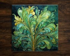 a painting on a wooden table with green and yellow designs in the center, as well as an acrylic paint effect