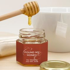 a honey jar filled with liquid next to a wooden spoon