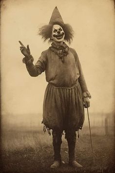 an old photo of a creepy clown holding two fingers up