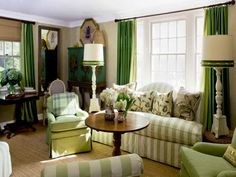 a living room filled with furniture and green curtains