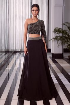 Black one shoulder embroidered blouse with one side split sleeve. Comes with overlap lehenga with embroidered waistband.
Component: 2
Pattern: Embroidered
Type Of Work: Beads
Neckline: Asymmetric
Sleeve Type: One side split sleeve
Fabric: Blouse: Net, Lehenga: Organza
Color: Black
Other Details: 
Embellished split sleeve
Overlap lehenga with embroidered waistband
Occasion: Sangeet - Aza Fashions Blouse With Skirt, Overlap Skirt, Baju Kahwin, Sangeet Outfit, Trendy Outfits Indian, Black Lehenga, Indian Outfits Lehenga, Lehenga Designs Simple, Gaun Fashion