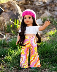 a doll is standing in the grass with her hands out