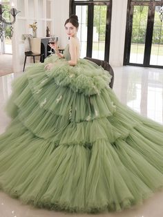 Step into a world of elegance and sophistication with our Sage Green Tiered Tulle Gown. This exquisite ball gown features a stunning tiered tulle skirt that creates a dramatic and voluminous silhouette, perfect for making a grand entrance. The corset back adds a touch of timeless charm while ensuring a perfect fit. The gown's sage green hue exudes a sense of tranquility and grace, making it an ideal choice for any formal occasion. Delicate embellishments and intricate detailing enhance the gown's luxurious appeal, while the off-shoulder neckline adds a romantic touch. Designed with comfort and style in mind, this gown allows you to move with ease and confidence. Whether you're attending a wedding, gala, or any special event, this Sage Green Tiered Tulle Gown promises to make you the center Evening Dress Plus Size, Prom Dress Green, Simple Satin Wedding Dress, Tulle Long Prom Dress, Nontraditional Wedding Dress, Antoinette Dress, Sweet 16 Dress, Tiered Tulle Skirt, Fairy Wedding Dress