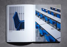 an open book with blue chairs and tables in the middle, on a gray surface