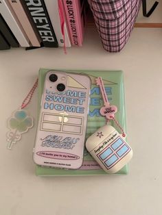 a cell phone case sitting on top of a table next to a book and keychain