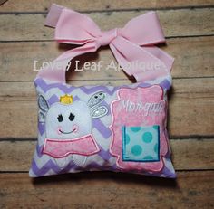 a small pillow with a pink bow on it