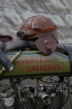 a black and white photo of a harley davidson motorcycle with a helmet on it's back