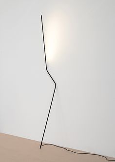 a lamp that is on top of a table next to a white wall and floor