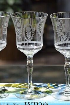 three wine glasses sitting on top of a blue tablecloth with the words pride to wine written below them