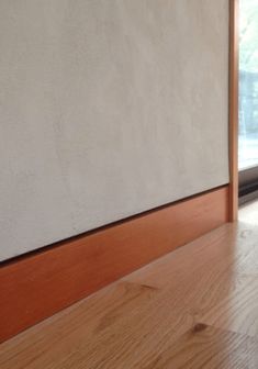 a cat sitting on the floor in front of a window looking out at something outside