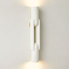 a white wall mounted light on the side of a wall with two lights attached to it