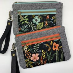 two zippered pouches with flowers and leaves on them, one has a lanyard strap