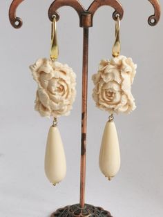 Dangling earrings with imitation ivory paste drops and cameo flowers in handmade ivory paste at Torre del Greco depicting flowers, 2.5 cm in size, closing to silver monachelle 925. 8 cm total length. Elegant Beige Flower Earrings For Gift, Elegant Beige Flower Earrings Gift, Elegant Cream Flower Earrings For Gift, Elegant Carved Flower Jewelry, Elegant Cream Flower Earrings, Elegant Beige Teardrop Jewelry, Elegant Beige Teardrop Earrings, Red Coral Earrings, Red Coral Necklace