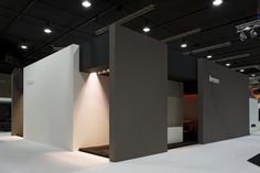 an exhibition booth with white walls and black flooring