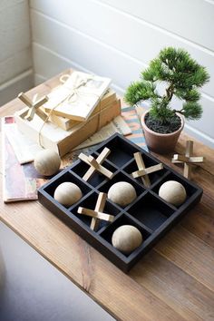 an assortment of wooden pegs are arranged on a table next to a bonsai tree