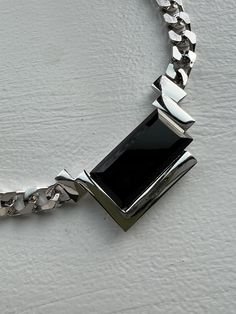 "1980s silver chrome chain necklace with rectangular black onyx detail. very rare piece by Kunio Matsumoto for Trifari. a bold piece, yet, timeless and very versatile. One of those that will always be in style. an incredible find and stunningly crafted - in excellent condition. measurements: total length, closed, measured inside: 16 1/2\" inches width of chain: a little over 1/4\" inch size of onyx framed center piece:  about 2 1/2\" inches wide and 1 1/4\" inch height - whole piece, frame & sto Modern Black Formal Chain Necklace, Modern Black Chain Necklace For Formal Occasions, Modern Rectangular Necklace With Polished Finish, Elegant Silver Chain Necklace With Rectangular Pendant, Modern Black Chunky Chain Jewelry, Modern Black Jewelry With Chunky Chain, Modern Polished Metal Chain Necklace, Formal Rectangular Silver Chain Necklace, Formal Silver Rectangular Chain Necklace