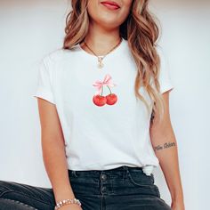 Cherry Bow Tee - a delightful blend of sweetness and style designed to capture the essence of feminine charm. This tee seamlessly combines the timeless allure of cherries with a dainty bow accent, creating a fashion-forward piece that's perfect for women with a taste for both whimsy and sophistication. Machine wash inside out with like colors. Tumble dry on low to medium heat. Do not iron directly on image. Please refer to size chart for reference before purchasing. If you want an oversized fit, go up 1-2 sizes. Please feel free to message with any questions. Please note, since items are made to order, we do not accept cancellations, returns or exchanges. Please make sure all sizing and shipping information is correct before placing an order! Mockups are used for demonstration purposes onl Trendy Crew Neck T-shirt With Cherry Print, Red Crew Neck T-shirt, Sweet Red Crew Neck Top, Sweet White Crew Neck Top, Sweet White Short Sleeve T-shirt, Spring Y2k Relaxed Fit T-shirt, Spring Y2k Style Relaxed Fit T-shirt, Y2k Style Relaxed Fit T-shirt For Spring, White Sweet T-shirt With Funny Print