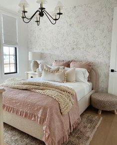 a bedroom with a large bed and pink comforter on top of it's headboard