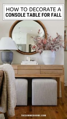 a console table with two stools and a mirror on the wall above it that says how to decorate a console table for fall