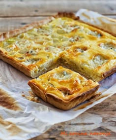 a quiche is cut into squares on top of wax paper