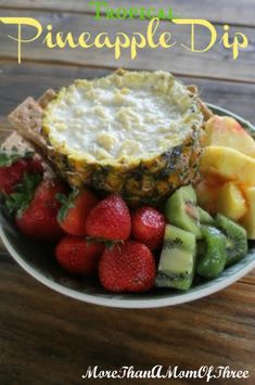 a pineapple dip surrounded by fruit on a plate