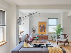 a living room filled with furniture and a painting on the wall next to a window