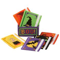 four cross stitch halloween coasters in different colors