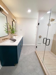 a bathroom with a walk in shower next to a sink and mirror on the wall