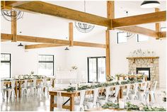 the tables are set up with white chairs and greenery on them for a wedding reception