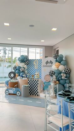 a room filled with lots of balloons and decorations on the wall next to a table